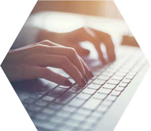 photo - closeup of a pair of hands poised over a computer keyboard
