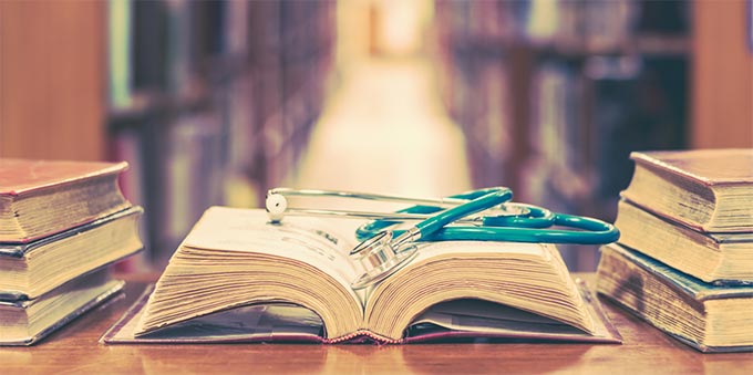 photo - a book on a table in a library, with a stethoscope resting on it