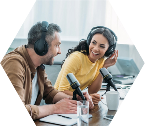 photo - two smiling people wearing headphones and speaking into microphones
