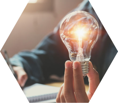 photo – closeup of someone holding a lit lightbulb