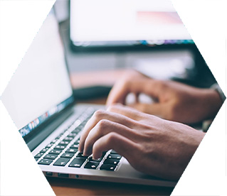 photo - closeup of someone's hands as they use a laptop