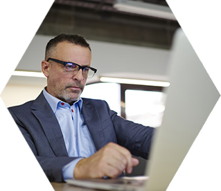 photo - a man wearing a suit uses a laptop