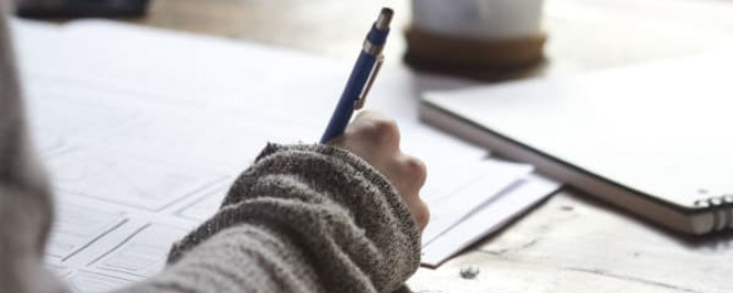 Photo – a closeup of a person filling in a document with a pen