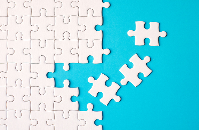 photo - a white jigsaw puzzle being constructed on a teal background