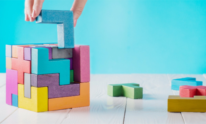 photo - a colourful wooden block puzzle being solved against a teal background
