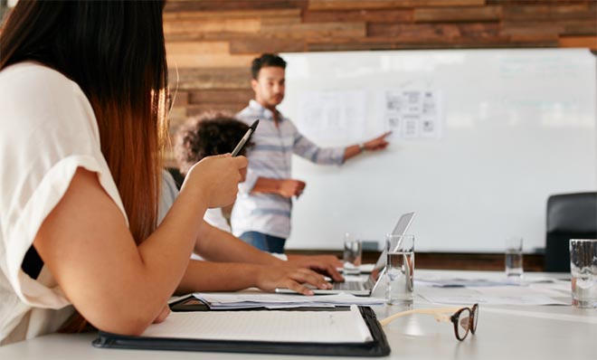 photo - an instructor shows students information on a white board